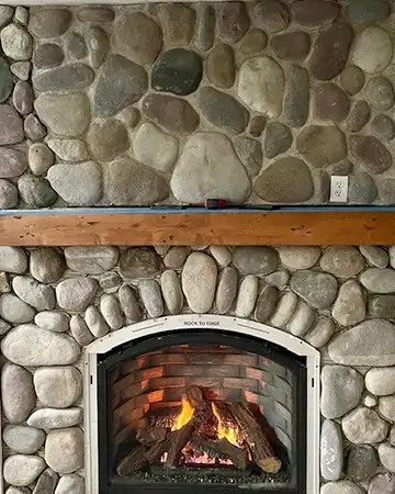 St. Joseph's expert fireplace installation of a inset gas fireplace with a custom stone frame. Call ADAMS & Son, Inc. HVAC Mechanical for a new fireplace, indoor or outdoor.